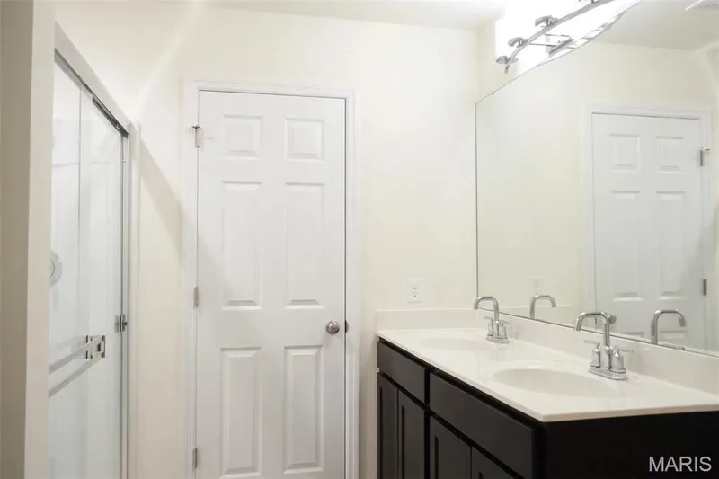 Dual vanity with undermount sinks, chrome fixtures, and a large mirror — 157 Day Lily Lane, Wentzville, MO 63385