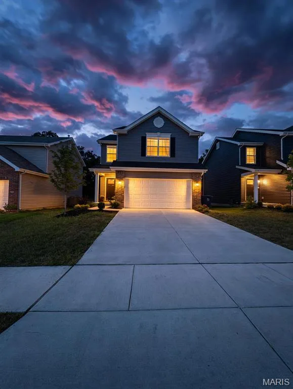 Two-story residence featuring a gabled roofline, front-facing garage, and a concrete driveway — 157 Day Lily Lane, Wentzville, MO 63385