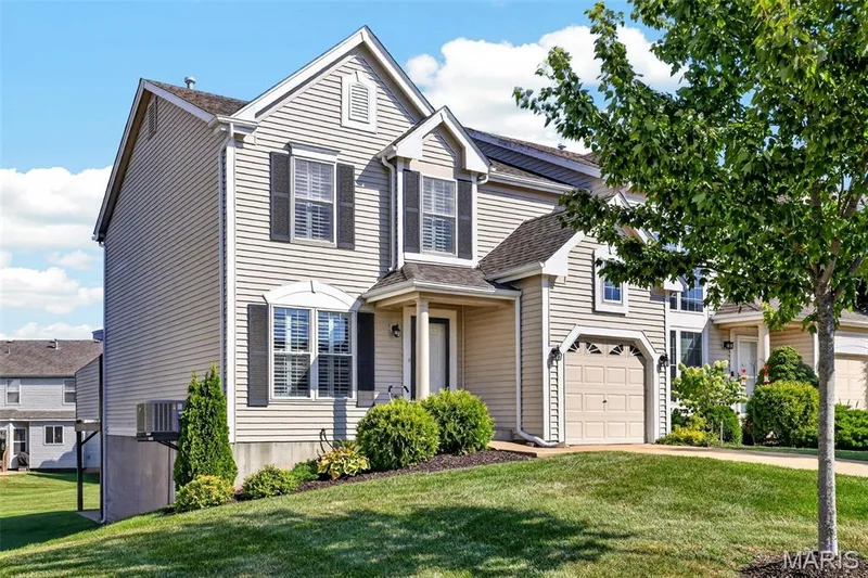 Light-colored siding exterior with dark shutters, attached garage, covered front entry, and established landscaping — 29 Edenshire Court #69B, Dardenne Prairie, MO 63368