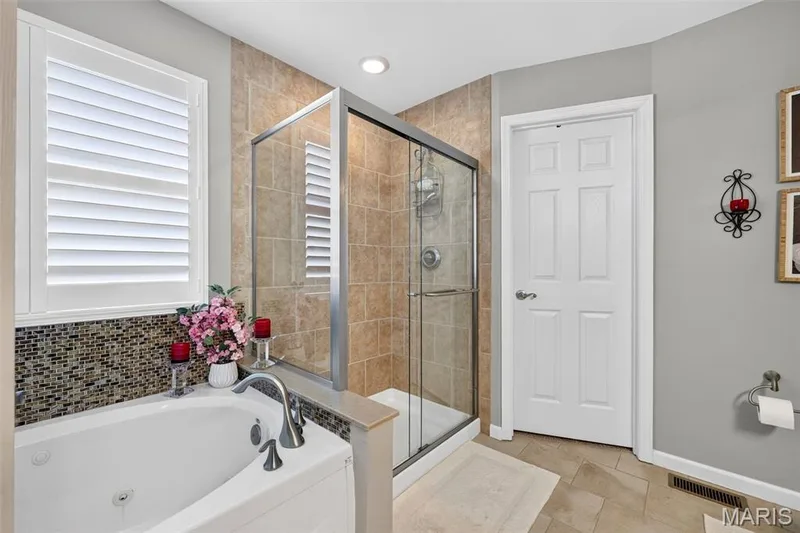 Soaking tub with a mosaic tile surround and plantation shutters — 29 Edenshire Court #69B, Dardenne Prairie, MO 63368