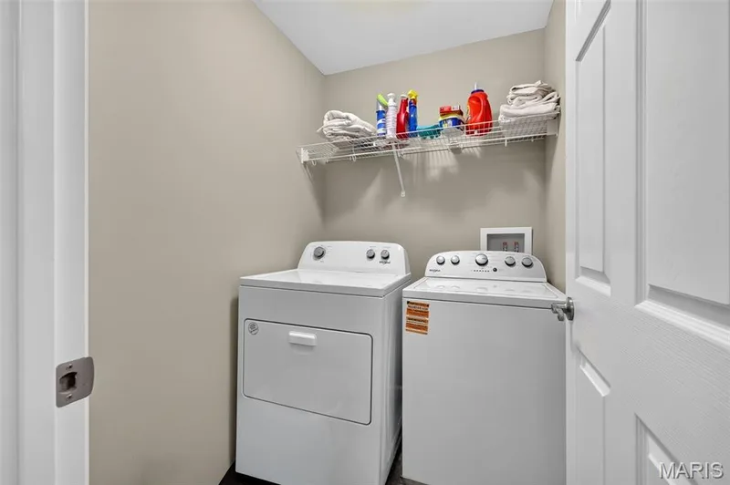Laundry area featuring a wire shelving unit, painted walls, and dark flooring — 29 Edenshire Court #69B, Dardenne Prairie, MO 63368