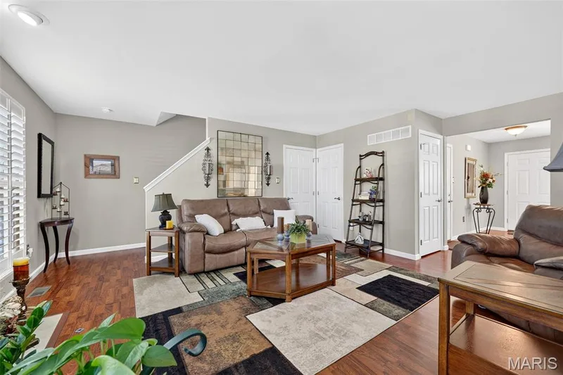 Wood-finish flooring throughout, white plantation shutters, white painted trim, recessed ceiling lighting, and a prominent staircase with white risers and handrail — 29 Edenshire Court #69B, Dardenne Prairie, MO 63368