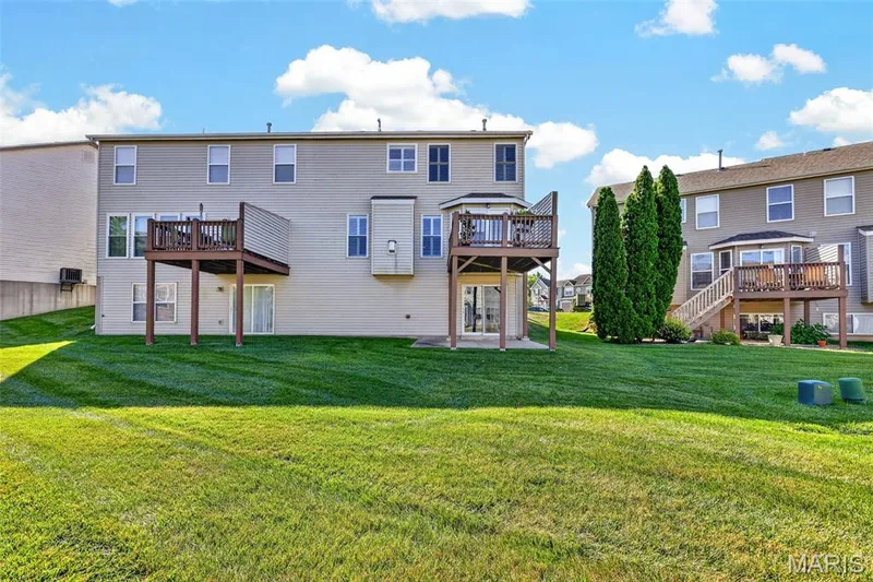 Expansive green lawn with two elevated wood decks featuring railings — 29 Edenshire Court #69B, Dardenne Prairie, MO 63368
