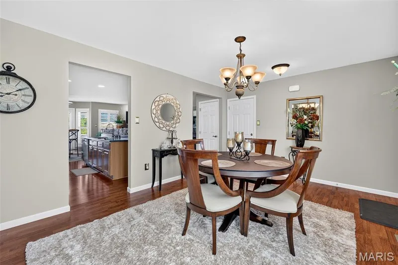 Dining area with wood-finish flooring, a chandelier, and a wide entryway — 29 Edenshire Court #69B, Dardenne Prairie, MO 63368