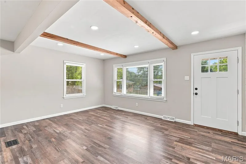 Recessed lighting illuminates the wood-finish flooring and exposed wooden ceiling beams — 1620 Dale Avenue, St Charles, MO 63301