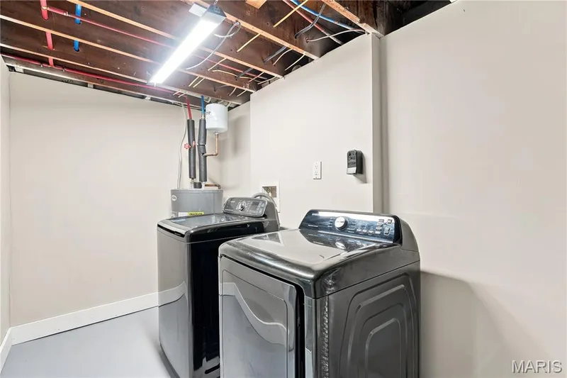 Utility area featuring a water heater, exposed ceiling joists, and a fluorescent light fixture — 1620 Dale Avenue, St Charles, MO 63301