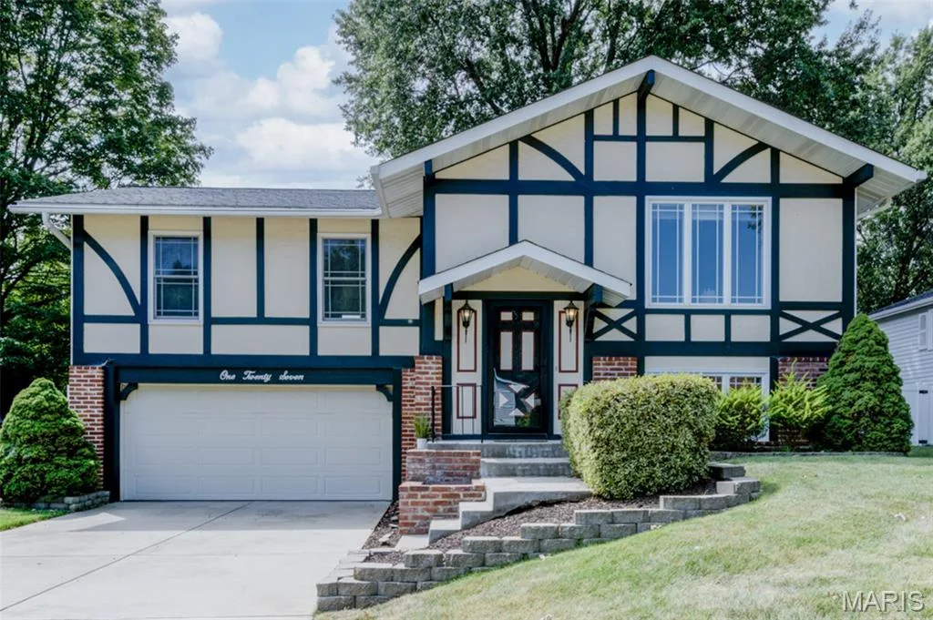 Tudor-style exterior with decorative dark trim, multi-pane windows, and an attached two-car garage — 127 Spring Leaf Drive, St Peters, MO 63376