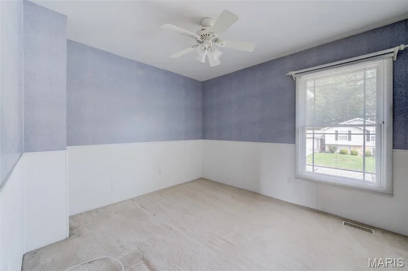 Carpeted flooring, white wainscoting, ceiling fan, window with blinds, and blue wallpaper — 127 Spring Leaf Drive, St Peters, MO 63376