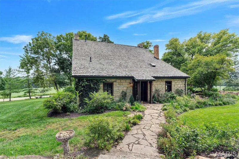 Stone exterior with a natural wood shake roof, complemented by a stone chimney — 2275 Highway F, Defiance, MO 63341