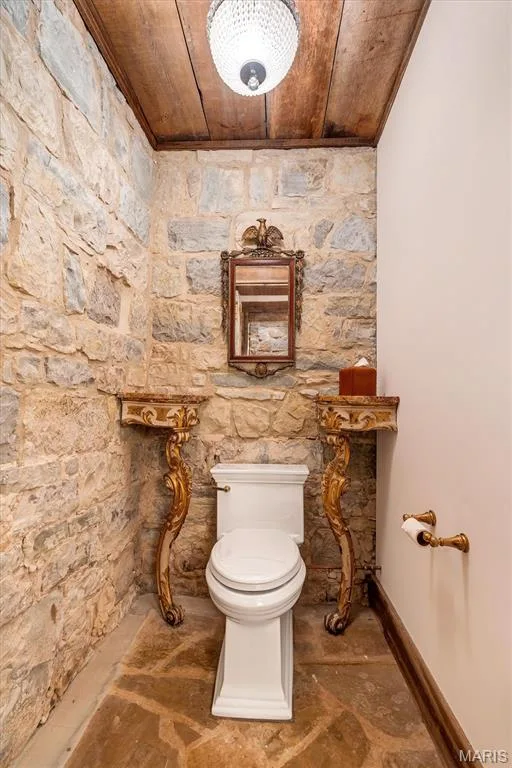 Stone accent walls, wood-paneled ceiling, stone flooring, and ornate wall consoles — 2275 Highway F, Defiance, MO 63341