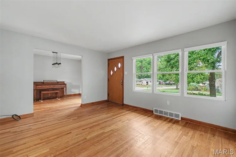 The living room boasts hardwood flooring throughout, with multiple windows to accentuate the abundant natural light. — 502 Pine Street, St Charles, MO 63301