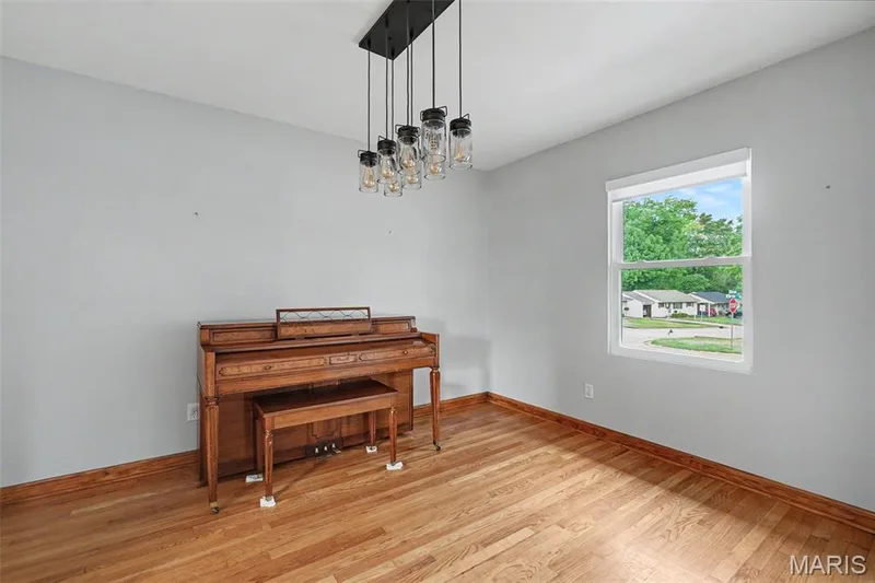 Hardwood flooring continues into the sitting/dining room that could also be considered for an office space. The contemporary multi-bulb chandelier sets the tone, you create the space. — 502 Pine Street, St Charles, MO 63301