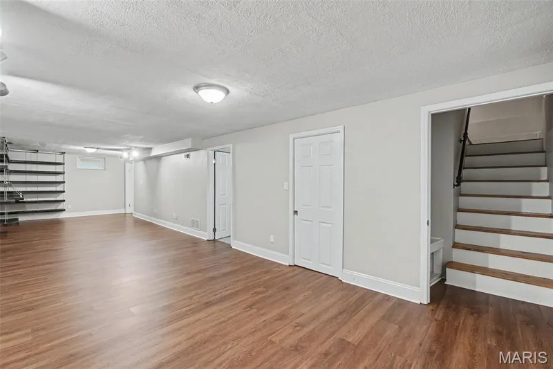 The lower level opens up to an expansive room with so many options for use.  The built-in shelving unit is a bonus that may help with that design process. — 502 Pine Street, St Charles, MO 63301