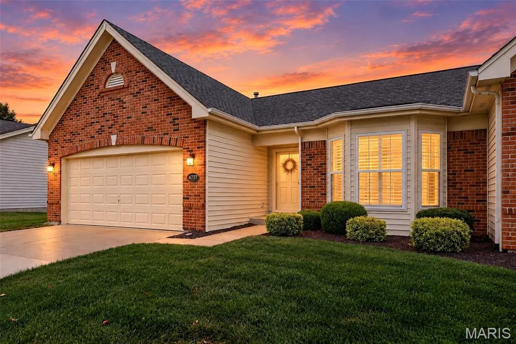 Brick and siding exterior with a dark shingle roof, featuring a bay window with plantation shutters, an attached garage, and established landscaping — 14737 Ladue Bluffs Crossing Drive, Chesterfield, MO 63017