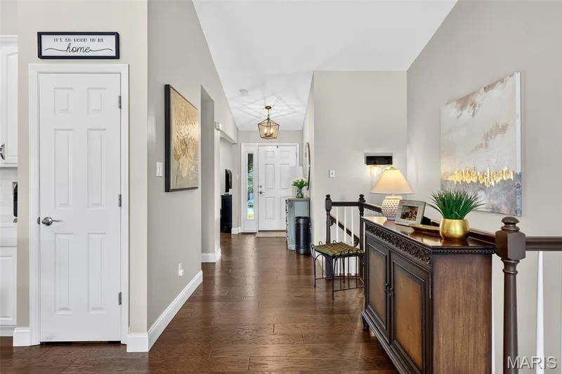 Hardwood flooring, painted interior walls, staircase with wood banister, and vaulted ceiling — 14737 Ladue Bluffs Crossing Drive, Chesterfield, MO 63017