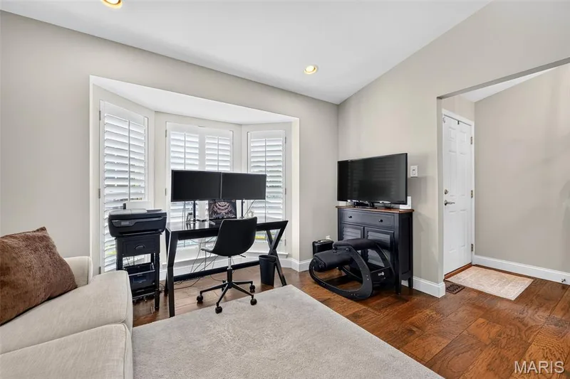 Bay window with plantation shutters, rich wood-finish flooring, recessed ceiling lighting, and neutral wall tones — 14737 Ladue Bluffs Crossing Drive, Chesterfield, MO 63017