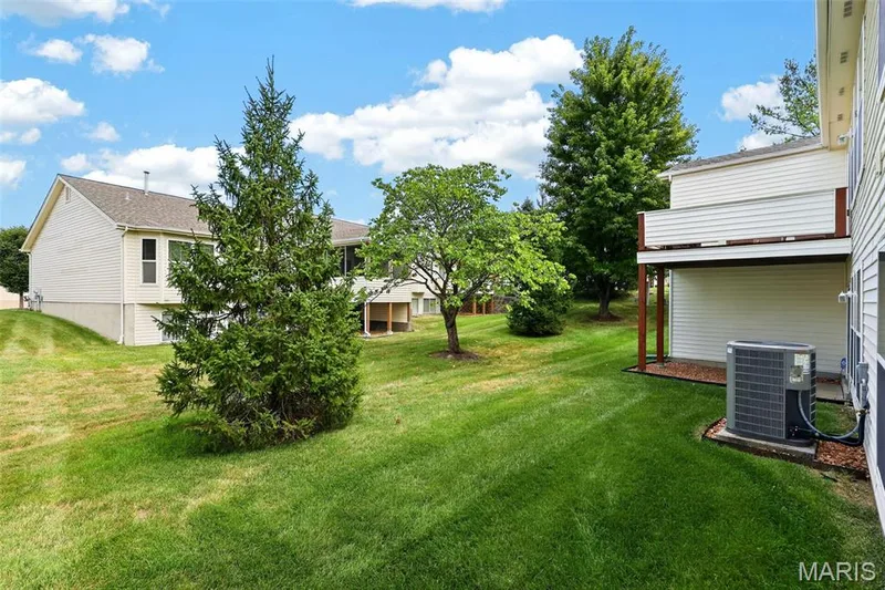 Expansive grassy lawn with mature trees and a dedicated outdoor living space — 14737 Ladue Bluffs Crossing Drive, Chesterfield, MO 63017