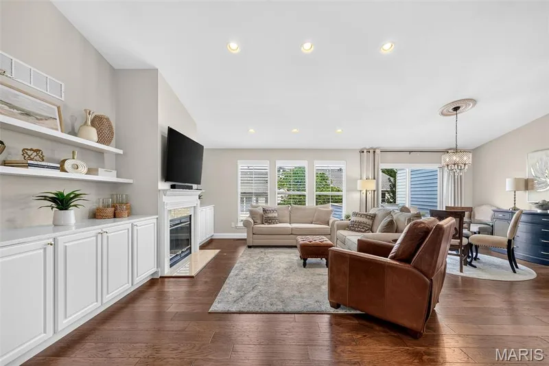 Hardwood-finish flooring throughout, recessed lighting, built-in shelving, fireplace, and crown molding detail — 14737 Ladue Bluffs Crossing Drive, Chesterfield, MO 63017