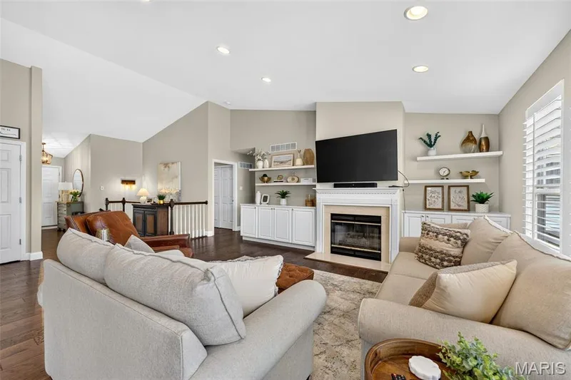 Vaulted ceilings, recessed lighting, wood-finish flooring, built-in cabinetry, and a fireplace with a mantel — 14737 Ladue Bluffs Crossing Drive, Chesterfield, MO 63017