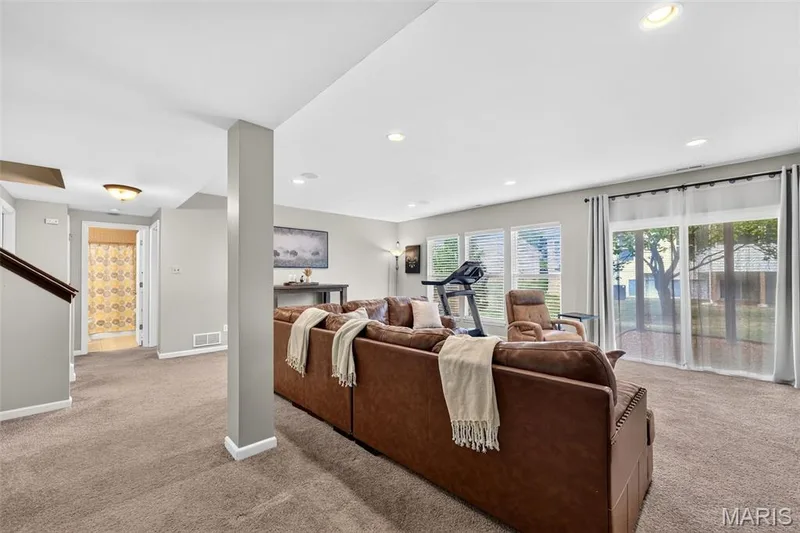 Recessed lighting, light gray painted walls, brown carpet flooring, multiple windows, and a sliding glass door providing outdoor access — 14737 Ladue Bluffs Crossing Drive, Chesterfield, MO 63017