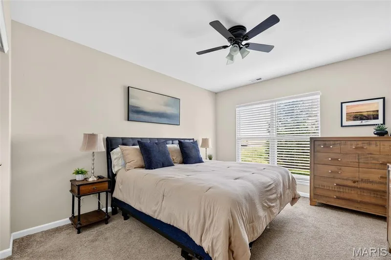 Neutral tone wall paint, textured carpeting, window with blinds, ceiling fan with integrated lighting, and a built-in closet door — 14737 Ladue Bluffs Crossing Drive, Chesterfield, MO 63017