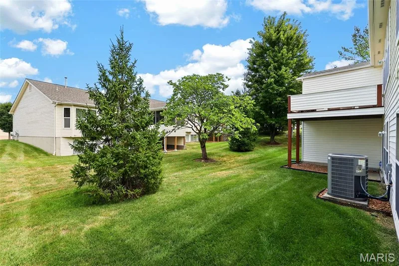 Expansive rear yard with a manicured lawn, established landscaping, and multi-level outdoor living space — 14737 Ladue Bluffs Crossing Drive, Chesterfield, MO 63017