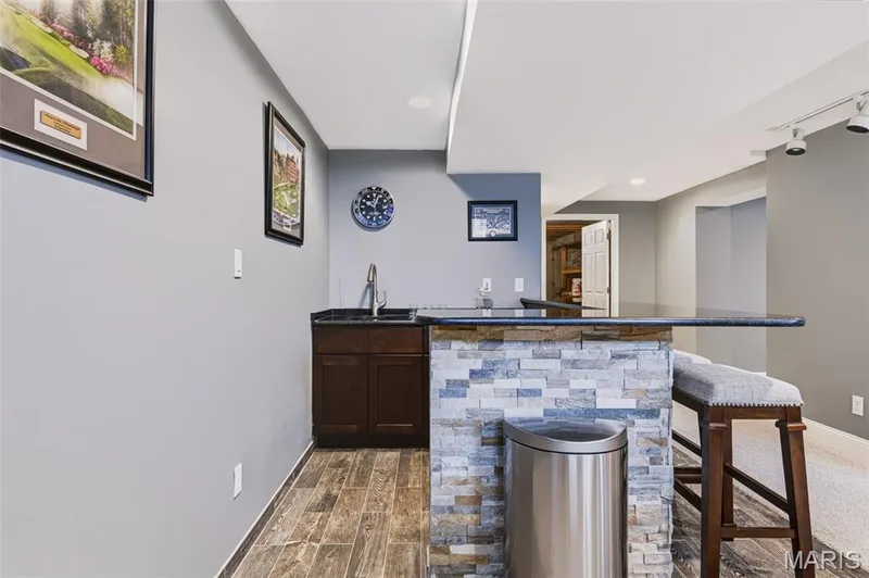 Beautiful granite and tiled bar with sink and beautiful cabinetry.  LVP underneath. — 209 Harbour Pointe Drive, Grover, MO 63040