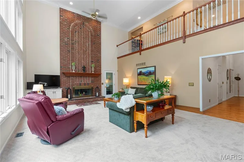 The two-story living area features a floor-to-ceiling brick, wood-burning fireplace  and access to an attached, screened-in side porch providing the best of indoor-outdoor living — 19342 Dogwood Valley Court, Wildwood, MO 63038