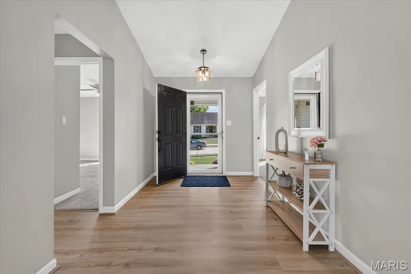 Wood-finish flooring throughout, light gray wall paint, and a modern ceiling light fixture — 89 Gregory Court, Wentzville, MO 63385