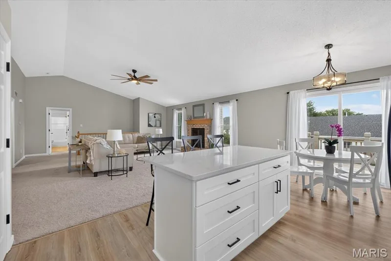 Open concept design with vaulted ceiling and a wood-finish flooring — 89 Gregory Court, Wentzville, MO 63385