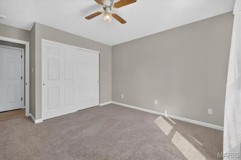 Neutral wall paint, ceiling fan, white paneled bifold closet doors, and carpet flooring — 89 Gregory Court, Wentzville, MO 63385