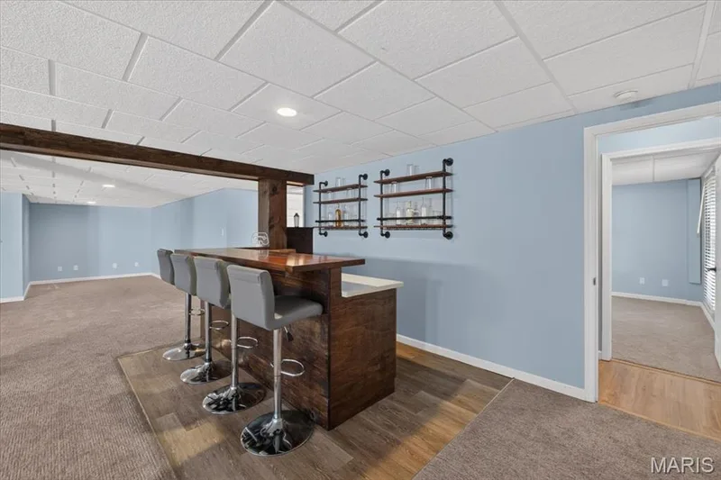 Built-in wood bar with a light-toned countertop, recessed lighting, and wood-finish flooring — 89 Gregory Court, Wentzville, MO 63385