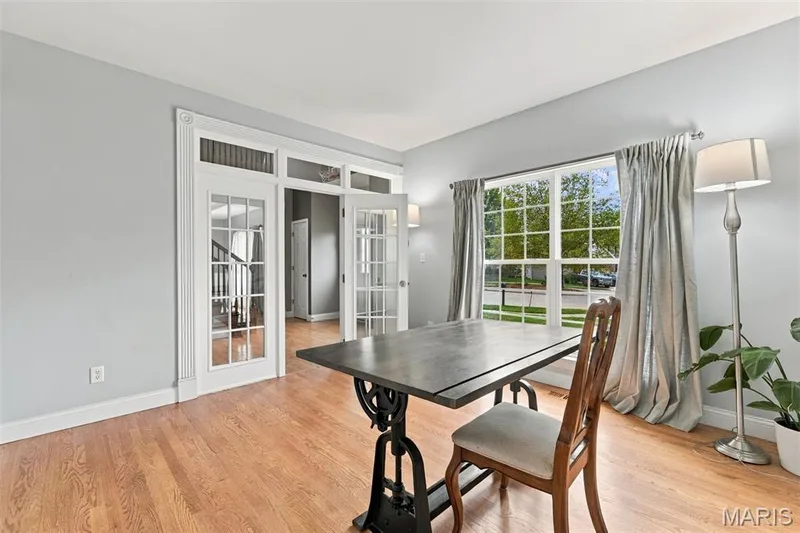 Office space with hardwood floors, transom windows, white trim detailing, and a large window — 1000 Gardenbridge Place, St Charles, MO 63303