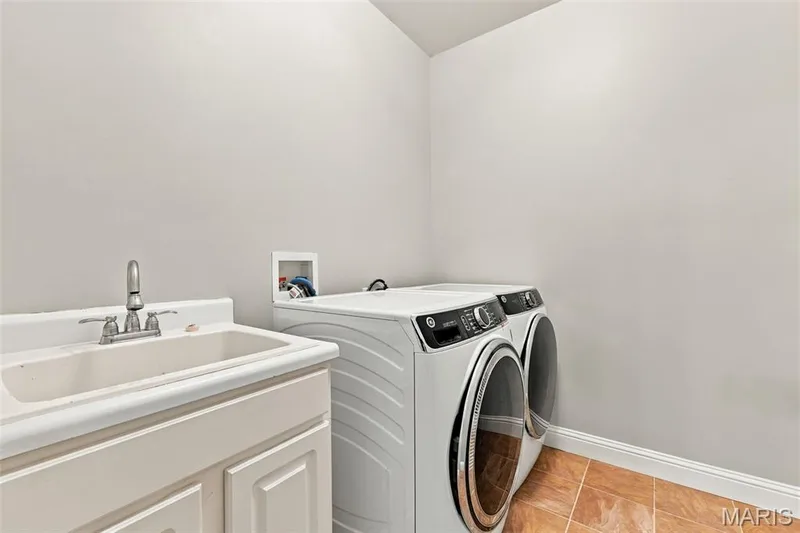 Laundry room featuring a utility sink with cabinetry — 1000 Gardenbridge Place, St Charles, MO 63303