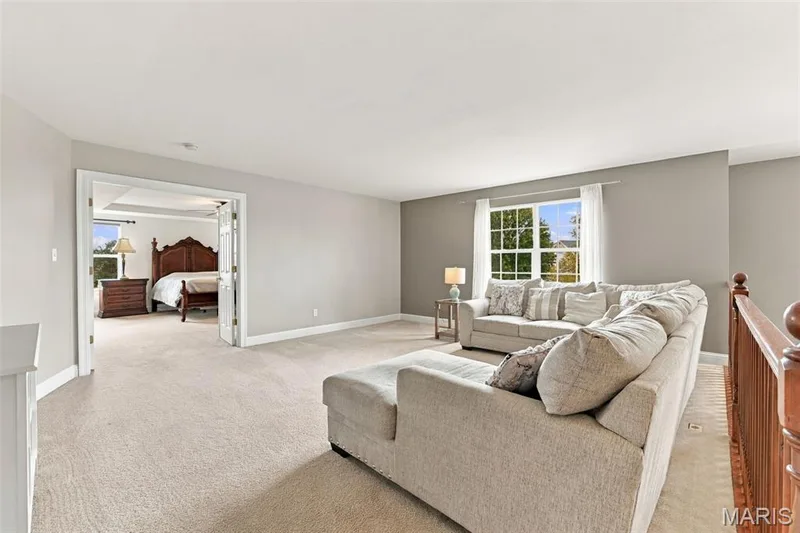 Expansive carpeted area with neutral wall tones and a window with white trim — 1000 Gardenbridge Place, St Charles, MO 63303
