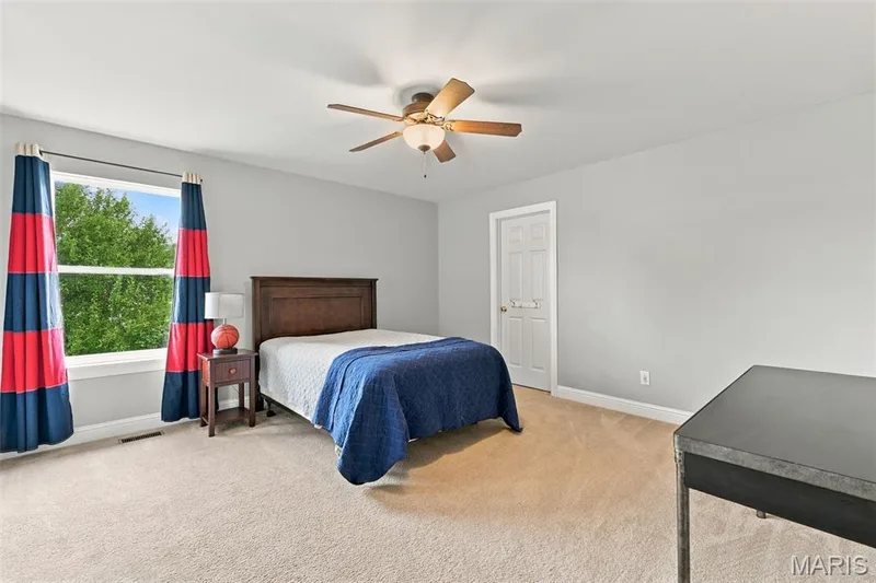 Spacious room with plush carpet flooring, a large window, and a ceiling fan with light fixture — 1000 Gardenbridge Place, St Charles, MO 63303