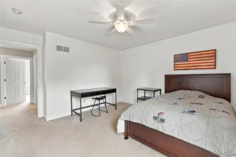 Plush carpeting, white paneled door, and ceiling fan with integrated lighting — 1000 Gardenbridge Place, St Charles, MO 63303