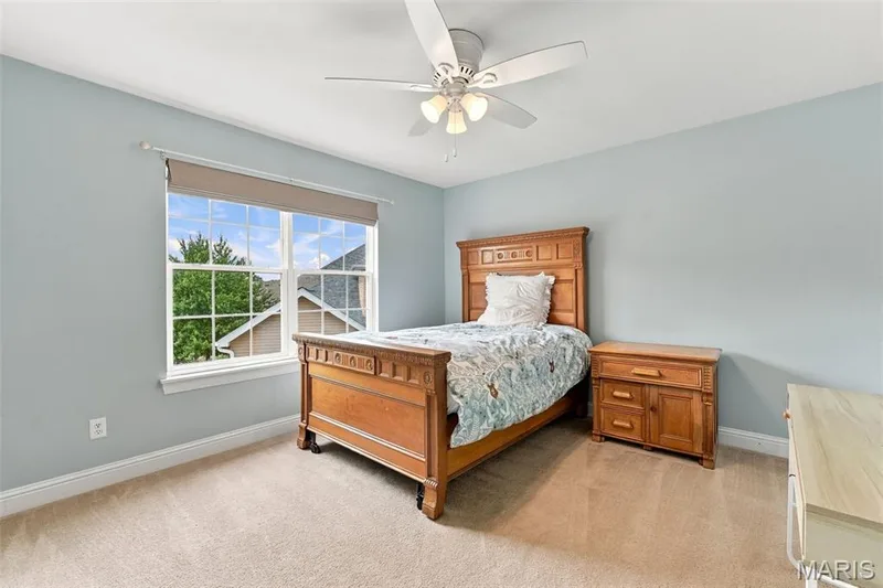 Light blue painted walls, neutral carpet, and a ceiling fan with integrated lighting — 1000 Gardenbridge Place, St Charles, MO 63303
