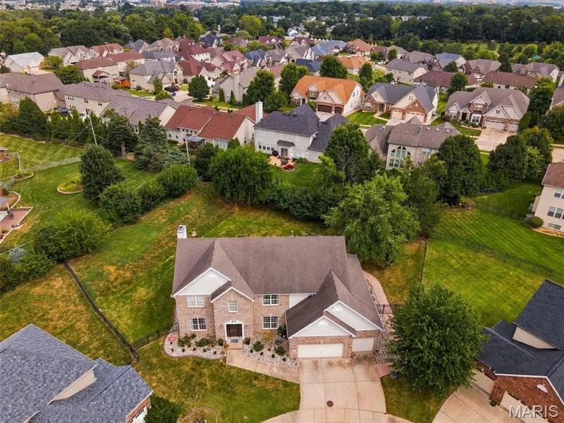 Brick exterior with a gabled roof and attached two-car garage — 1000 Gardenbridge Place, St Charles, MO 63303