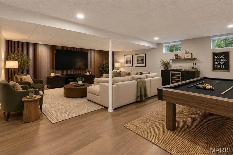 Virtually staged-Expansive recreation room featuring newer flooring, recessed lighting, and a dedicated entertainment wall with slat wood-like paneling — 113 Christine Cay Court, St Charles, MO 63304