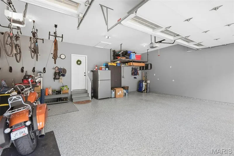 Garage with epoxy flooring. Bike mounts are excluded — 423 Cottage Grove Drive, Wentzville, MO 63385