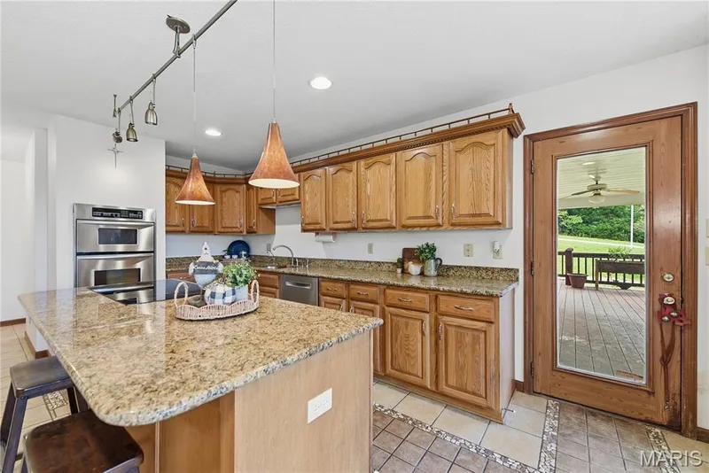 Large center island with breakfast bar and granite countertops — 1409 Boone Valley Ridge, Augusta, MO 63332