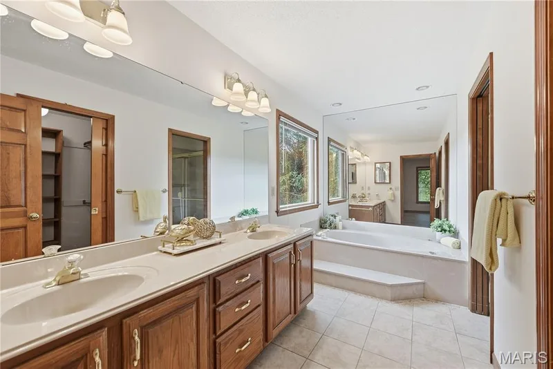 Double bowl vanity and jetted soaking tub in the primary bath — 1409 Boone Valley Ridge, Augusta, MO 63332