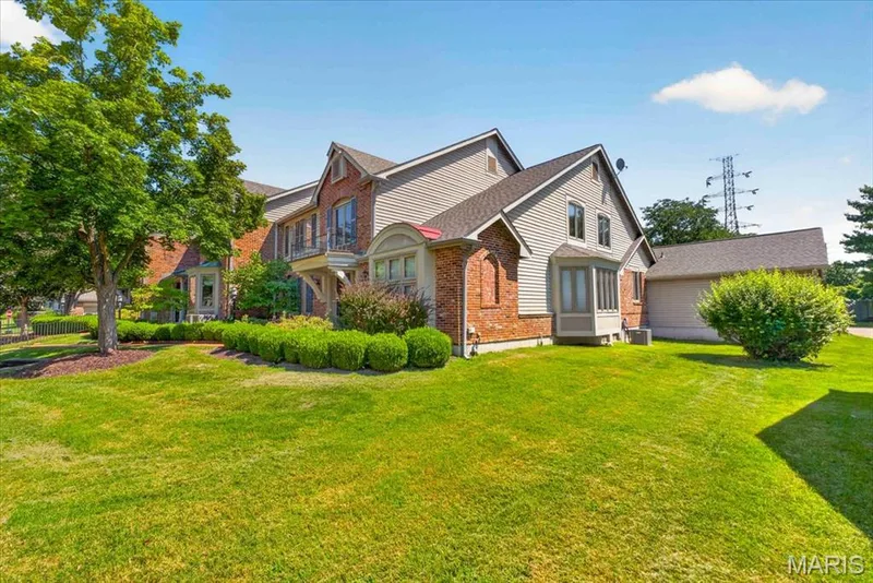 Brick and siding exterior with a multi-level roofline, featuring mature trees and established landscaping — 14418 W Open Meadow Court W, Chesterfield, MO 63017