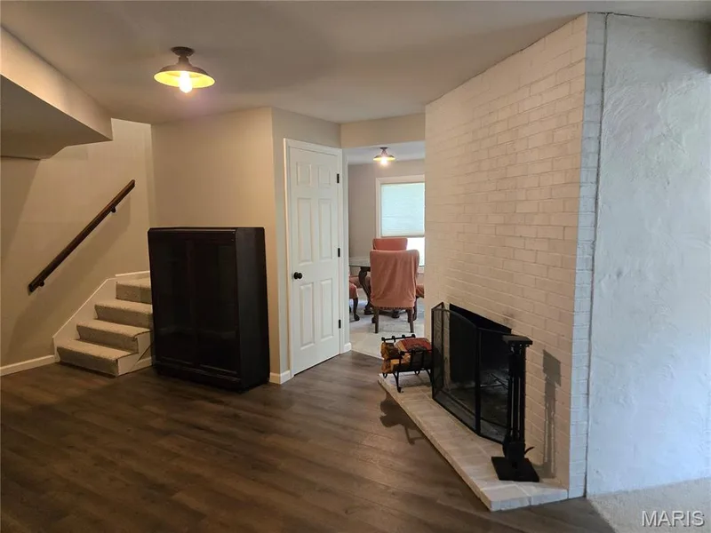 Entry area of basement showing one side of the see-through woodburning fireplace. — 266 Savoy Drive, Lake St. Louis, MO 63367