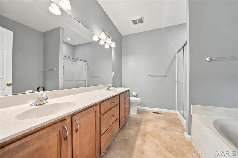 Primary Bathroom with dual vanities, soaker-tub, and walk-in shower. — 17124 Windsor Crest Boulevard, Glencoe, MO 63038