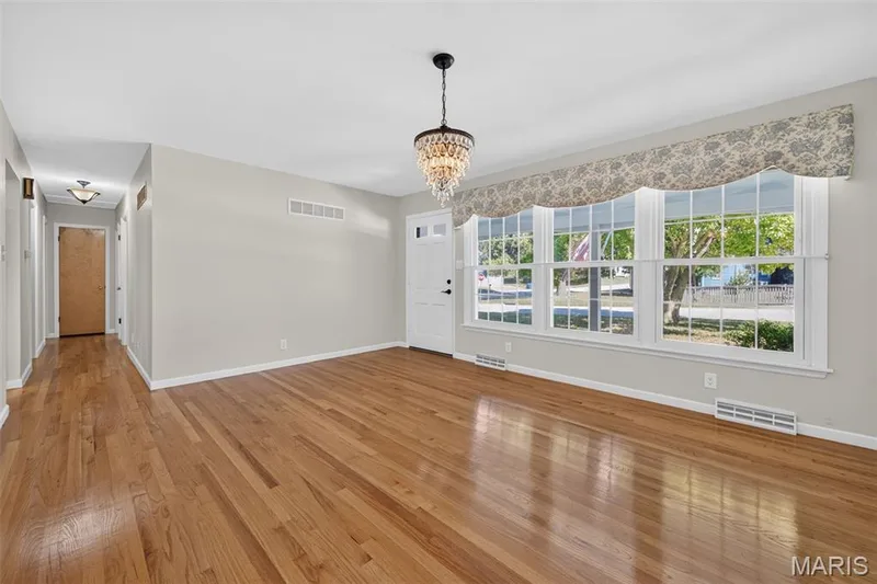 The same front room unstaged, Also flexes to a separate dining area - highlighting the hardwood floors, large front window and generous wall space. — 2913 Cypress Drive, St Charles, MO 63301