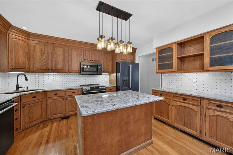 Spacious kitchen with granite countertops, abundant cabinetry, center island and skylight. — 2913 Cypress Drive, St Charles, MO 63301