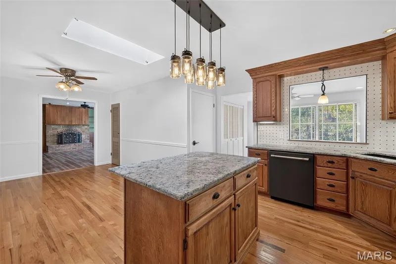 Center island provides additional prep space, with hardwood flooring throughout the kitchen. — 2913 Cypress Drive, St Charles, MO 63301