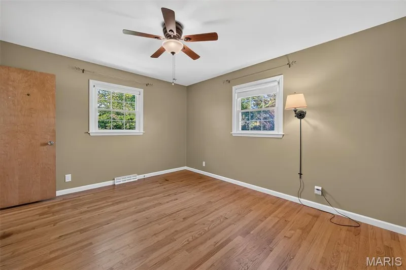 Primary bedroom with hardwood flooring and plenty of natural light. — 2913 Cypress Drive, St Charles, MO 63301